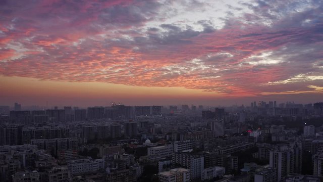 Bird eye view on Guangzhou endless suburb districts during epic red sunset with clouds, China, Guangdong.