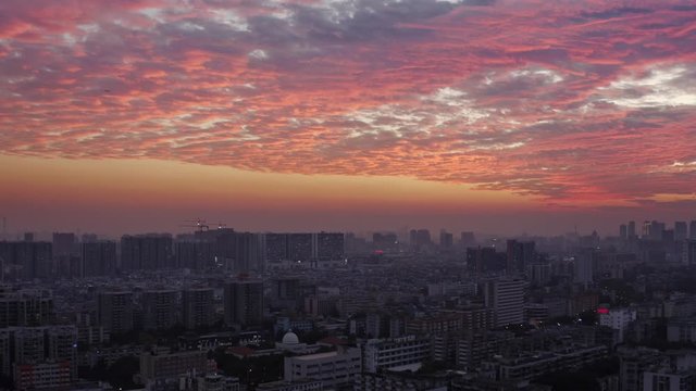 Bird eye view on Guangzhou endless suburb districts during epic red sunset with clouds, China, Guangdong.