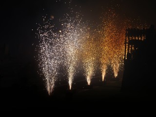 Medium wide shot of a burst of fireworks to celebrate an event, dark background