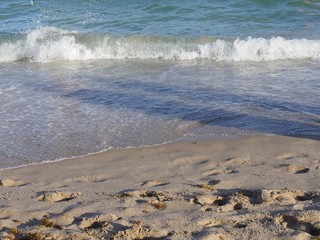 Clear waves rolling on a fine sand beach