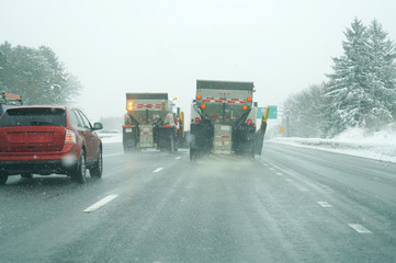 Snowplow spreading salt on the highway