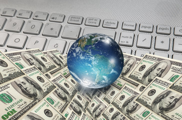 Glass globe on the keyboard with US dollars "Elements of this image furnished by NASA "