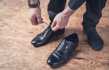 Man tying laces of shoes.