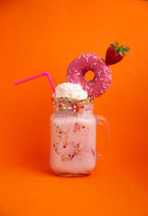 Delicious dessert strawberry smoothie with pink bagel and cream