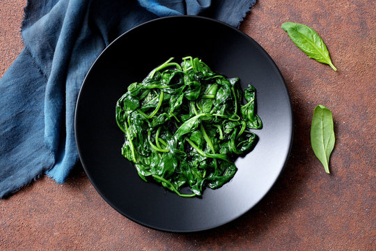 spinaci bolliti in piatto ceramica nera