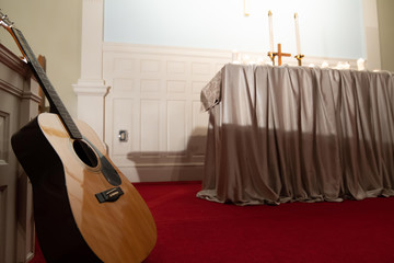 Obraz na płótnie Canvas guitar standing at church altar before service