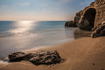 Beach on the Mediterranean coast in Nerja. Sandy beach on the Spanish coast of Costa del Sol. Stone...