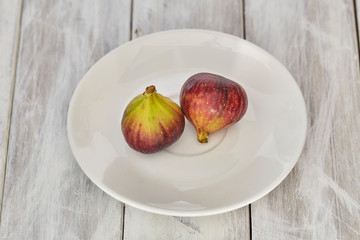 figs on a plate on white wooden