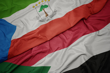 waving colorful flag of sudan and national flag of equatorial guinea.