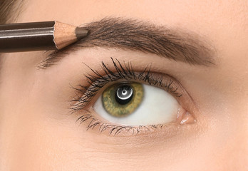 Naklejka premium Young woman undergoing eyebrow correction procedure, closeup