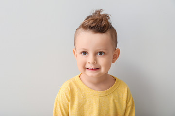 Fototapeta premium Portrait of cute little boy on light background