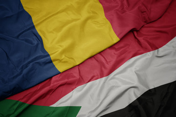 waving colorful flag of sudan and national flag of chad.