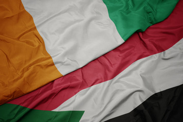 waving colorful flag of sudan and national flag of cote divoire.