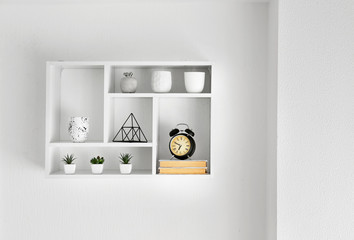 Shelf with decor hanging on white wall