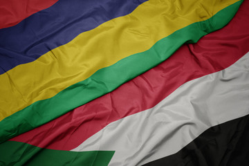 waving colorful flag of sudan and national flag of mauritius.