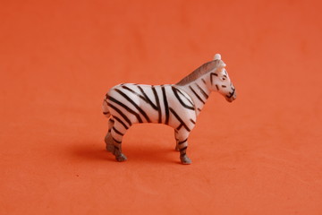 plastic toy with zebra shape in color background