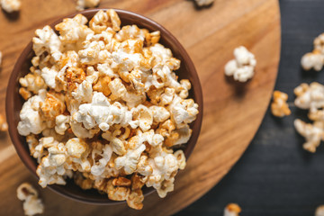 Bowl with tasty popcorn on table, closeup