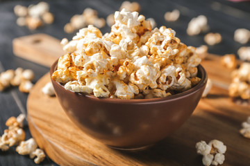 Bowl with tasty popcorn on table, closeup