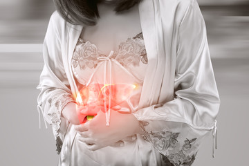 A woman in satin nightwear clutch the liver under bust
