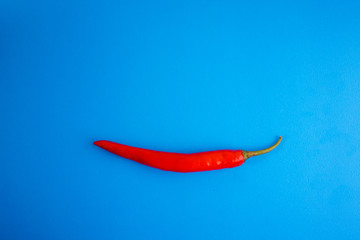 A close up of red hot chili pepper over blue background.