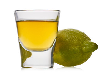 glass with strong alcoholic drink and lemon