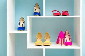 Shelf unit with stylish shoes near color wall