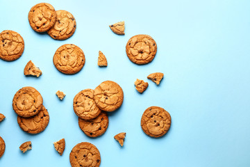 Tasty cookies with chocolate chips on color background