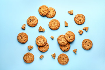 Tasty cookies with chocolate chips on color background