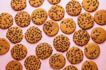 Tasty cookies with chocolate chips on color background
