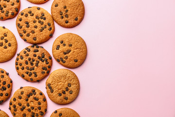 Tasty cookies with chocolate chips on color background