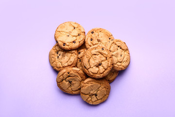Tasty cookies with chocolate chips on color background