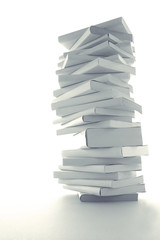 積み重ねた白い本とノートパソコン