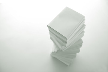 積み重ねた白い本とノートパソコン