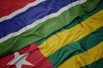 waving colorful flag of togo and national flag of gambia.