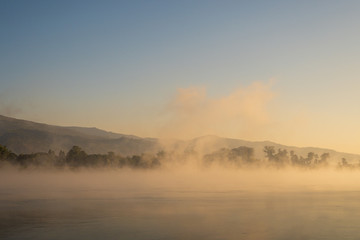 Fototapeta na wymiar Winter morning, water vapor evaporates from the river. Amazing winter landscape.