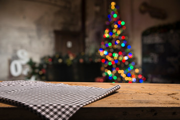Empty table in front of christmas tree with decorations background. For product display montage.