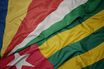 waving colorful flag of togo and national flag of seychelles.