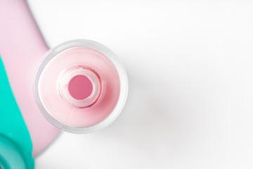 Pastel color spilled nail polish bottles over white