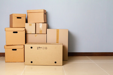 Cardboard boxes for moving on the floor against grey wall