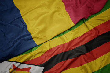 waving colorful flag of zimbabwe and national flag of chad.