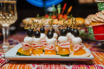 Appetizer of vegetables and ham on a skewer.