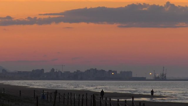 people walking on beach under evening sky, coastal seascape