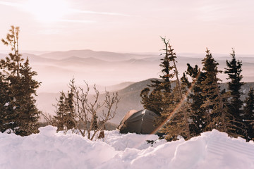 Couple in winter in the mountains at sunset