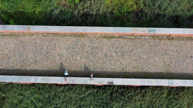 Family people tourists walking on masonry path way. Aerial drone shot