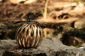 Outdoor metal pumpkin decoration on rock