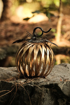 Outdoor metal pumpkin decoration on rock