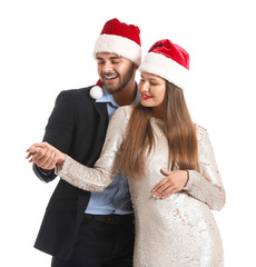 Happy couple in Santa Claus hats on white background