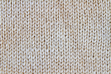 Beige knitted textured background. Closeup