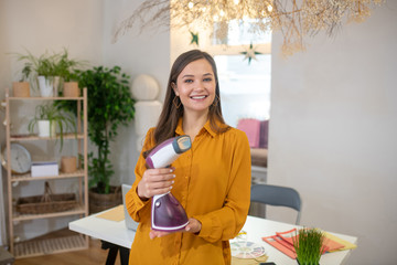 Positive cheerful woman presenting a household device