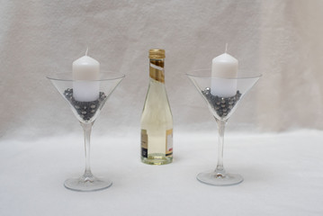 cocktailglaeser kerzenhalter mit weissen kerzen gefuellt mit perlen deko und mini sektflasche